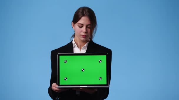 一个女孩用彩色按键笔记本电脑在蓝色背景下微笑的4K视频 情感的概念 — 图库视频影像