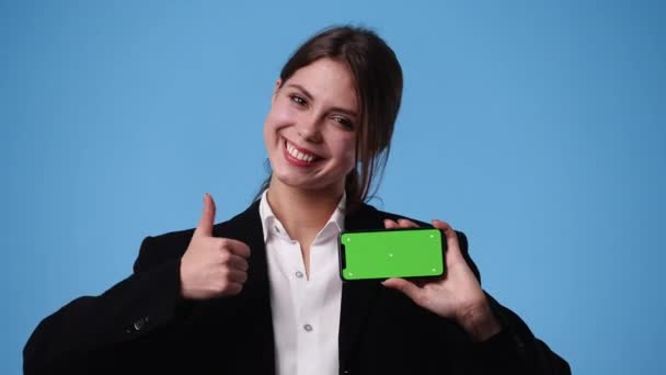 一个女孩在蓝色背景下使用彩色按键电话拍摄的4K视频 — 图库视频影像