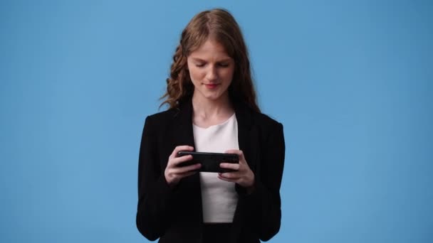 Vídeo Uma Menina Usando Seu Telefone Sobre Fundo Azul Conceito — Vídeo de Stock