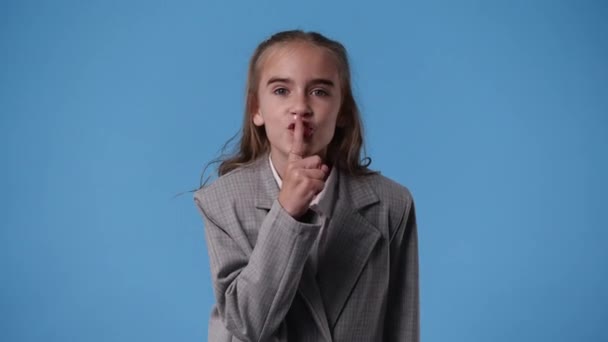 一个女孩在蓝色背景上显示沉默标志的4K视频 情绪的概念 — 图库视频影像