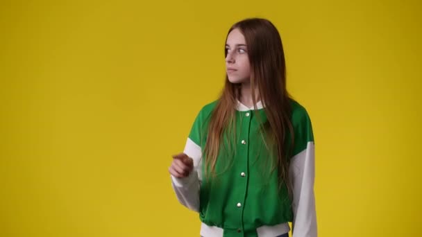 Video One Girl Pointing Left Showing Thumb Yellow Background Concept — Stock Video
