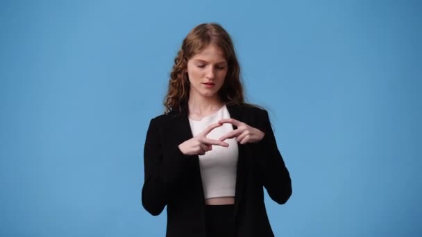 4Kビデオの女の子作る心の形で彼女の手で青の背景 愛の感情の概念 — ストック動画