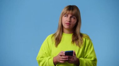 4k video of one girl sending messages on blue background. Concept of emotions.