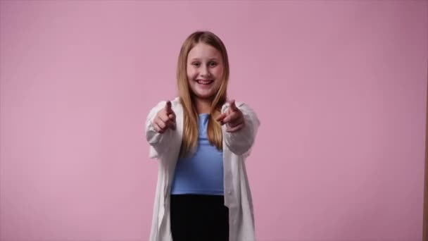 4K视频中 一个女孩竖起大拇指 在粉色背景下微笑 情绪的概念 — 图库视频影像