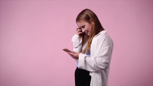 Pembe Arka Planda Telefonla Mesaj Yazan Genç Bir Kızın Videosu — Stok video