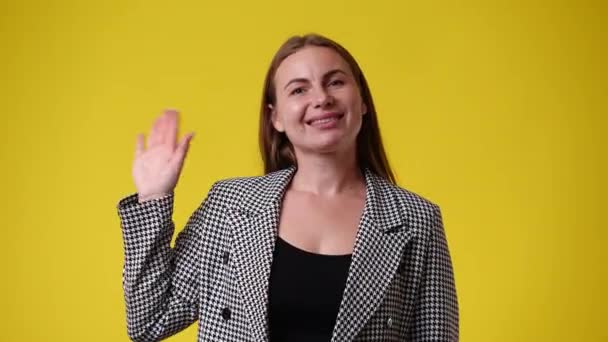 Video Una Mujer Saluda Alguien Sobre Fondo Amarillo Concepto Emociones — Vídeos de Stock