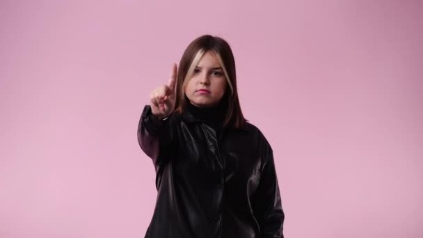 ピンク色の背景にネガティブに反応する1人の少女の4K動画 感情の概念 — ストック動画