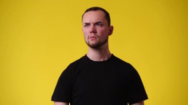 Sarı arka plandaki pis kokuya karşı burnunu kapatan bir adamın 4K videosu. Duyguların kavramı.