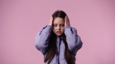 Pembe arka planda negatif tepki veren bir çocuğun 4k yavaş çekim videosu. Duyguların kavramı.