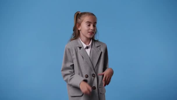 青色の背景の後ろから何かを伝え 示す1人の女の子の4Kビデオ 感情の概念 — ストック動画