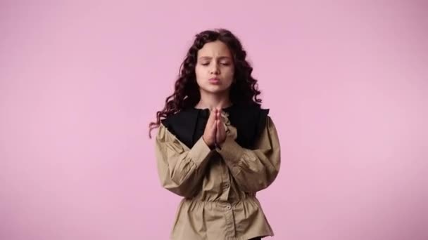 ピンクを背景に何かを嘆願する1人の若い女の子の4Kビデオ 感情の概念 — ストック動画