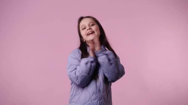 ピンクを背景に手をたたいて笑顔を見せる1人の子供の4K動画 感情の概念 — ストック動画