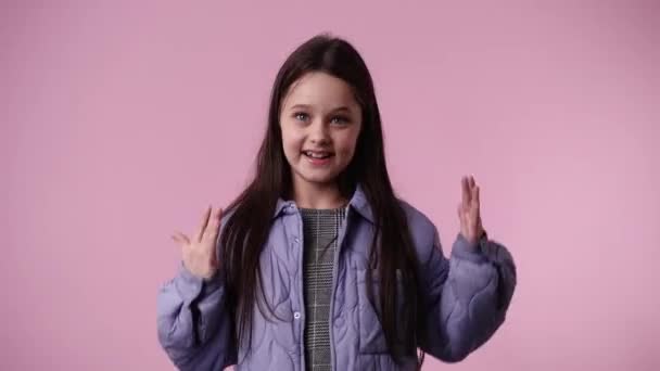 ピンク色の背景に頭をなでて喜ぶ少女1人の4Kビデオ 感情の概念 — ストック動画