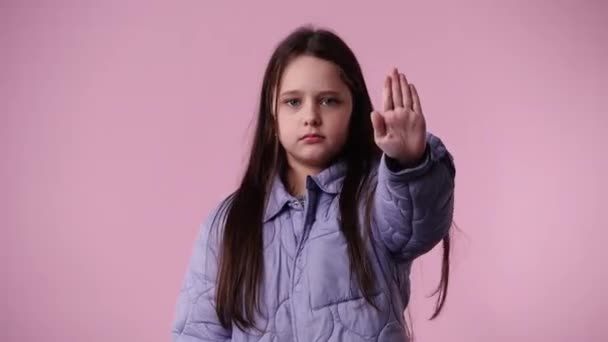 ピンクの背景の上に何かに立ち止まり 否定的に反応する1人の子供の4Kビデオ 感情の概念 — ストック動画