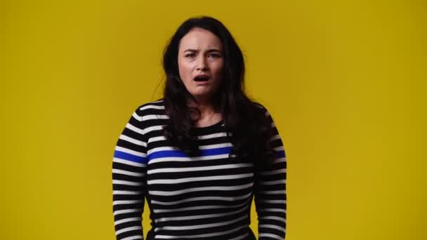 黄色の背景の上にビデオのためにポーズ1人の女性の4Kビデオ 感情の概念 — ストック動画