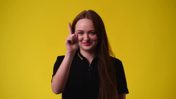 一个女孩的4K视频要求在黄色背景下给某人打电话 情绪的概念 — 图库视频影像