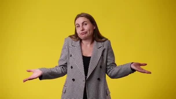 Video Jedné Ženy Která Pochybuje Mává Rukama Nad Žlutým Pozadím — Stock video