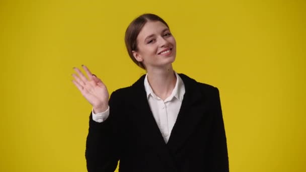 1人の女の子の4Kビデオは黄色の背景の上に誰かにこんにちはと言います 感情の概念 — ストック動画