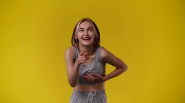 4k video of one girl posing for a video on yellow background. Concept of emotions.