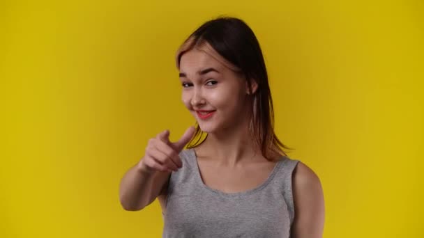 頭の近くで電話のジェスチャーをする女の子の4Kビデオ黄色の背景に私のサインを呼び出します 通信を提供する記号の呼び出しの概念 — ストック動画