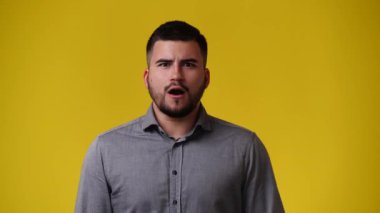Sarı arka planda duygusal bir adamın 4k videosu. Duyguların kavramı.