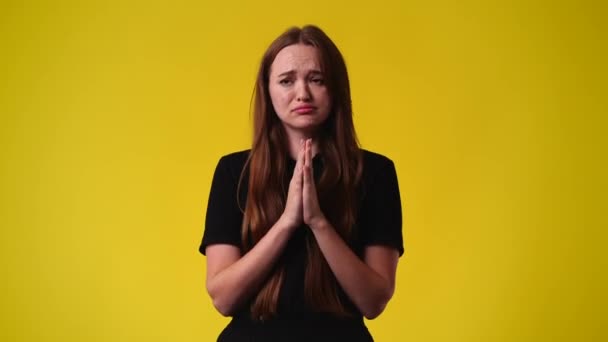 黄色の背景で何かを求めている1人の女の子の4Kビデオ 感情の概念 — ストック動画