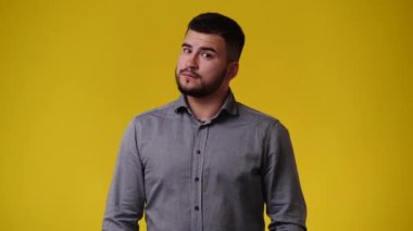 Sarı arka planda bir adamın boş duygularının 4K videosu. Boş duygu kavramı.