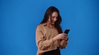 4k video of one girl sending messages on blue background. Concept of emotions.