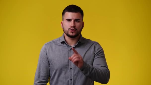 黄色の背景でビデオをポーズしている1人の男の4Kビデオ 感情の概念 — ストック動画