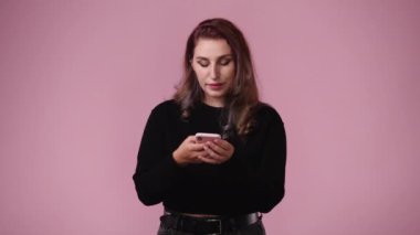 4K video 'da, pembe arka planda büyük gözleri olan bir kız el kaldırıyor. Duyguların kavramı.