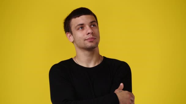 4K视频 一个男人在黄色背景下 脸上有深思熟虑的表情 有思想的人的概念 — 图库视频影像