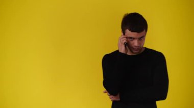 4k video of one man using phone over yellow background. Concept of emotion.