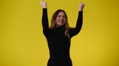 Bir kızın sarı arkaplanda poz verdiği 4k video. Duygu kavramı..