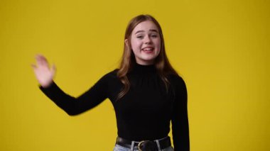 Sarı arka planda kurnaz yüz ifadesi olan bir kızın 4K videosu. Fikirleri olan kız kavramı.