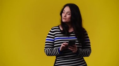 4k video of one woman posing for a video on yellow background. Concept of emotions.