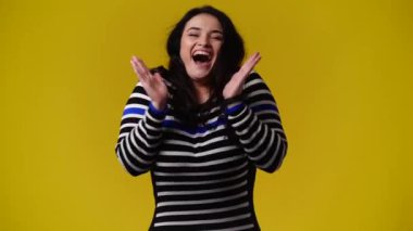 4k video of one woman posing for a video on yellow background. Concept of emotions.