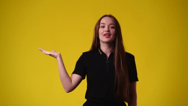 Vídeo Uma Garota Apontando Para Esquerda Mostrando Polegar Fundo Amarelo — Vídeo de Stock