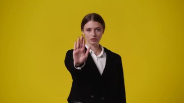 Sarı arka plandaki bir şeye negatif tepki veren bir kızın 4K videosu. Duyguların kavramı.