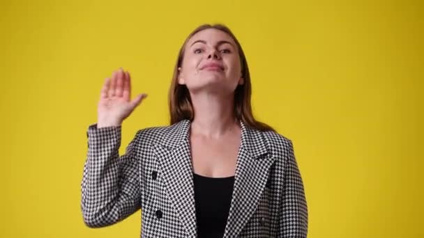 Video Una Mujer Saluda Alguien Sobre Fondo Amarillo Concepto Emociones — Vídeos de Stock