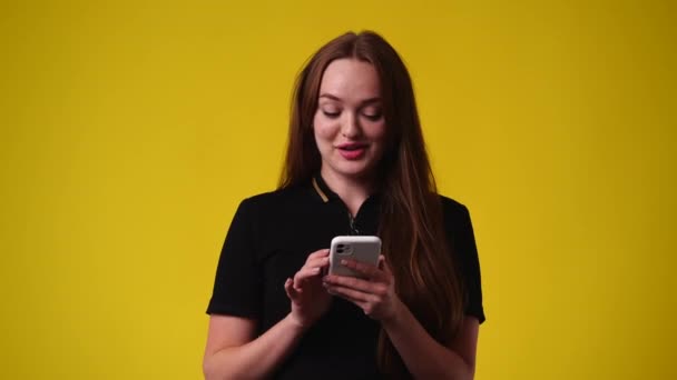Video Jedné Dívky Která Používá Telefon Usmívá Přes Žluté Pozadí — Stock video