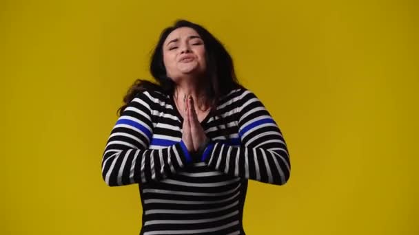 黄色を背景に何かを懇願する一人の女の4Kビデオ 感情の概念 — ストック動画