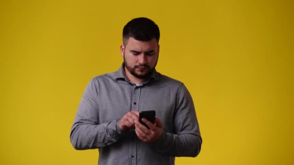 Video Muže Který Používá Telefon Přes Žlutý Backgrpound Pojetí Emocí — Stock video
