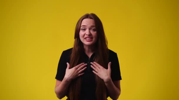 黄色い背景にネガティブな表情の可愛い女の子の4K動画 感情の概念 — ストック動画