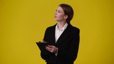 Sarı arka planda not defteri olan bir kızın 4K videosu. Duyguların kavramı.
