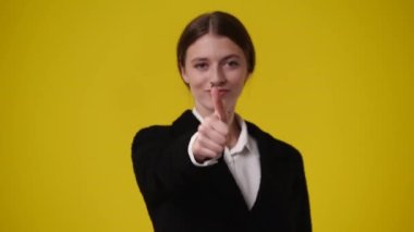 Sarı arka planda kameraya bakan bir kızın 4K videosu. Duygu kavramı..