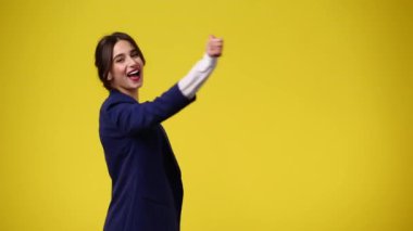 Sarı arka planda kameraya bakan bir kızın 4K videosu. Duygu kavramı..