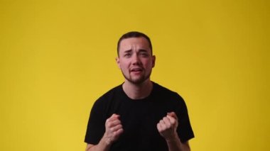 Sarı arka planda birini destekleyen bir adamın 4K videosu. Duyguların kavramı.