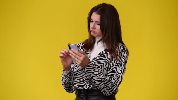 Video Una Chica Que Usa Teléfono Sobre Fondo Amarillo Concepto — Vídeos de Stock