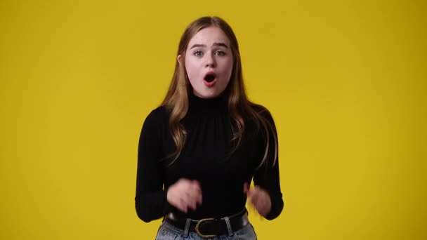 黄色い背景にびっくりする1人の少女の4Kスローモーションビデオ 感情の概念 — ストック動画