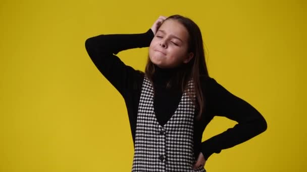 4K视频 一个女孩摸着她的头发 在黄色的背景上思考着什么 情绪的概念 — 图库视频影像